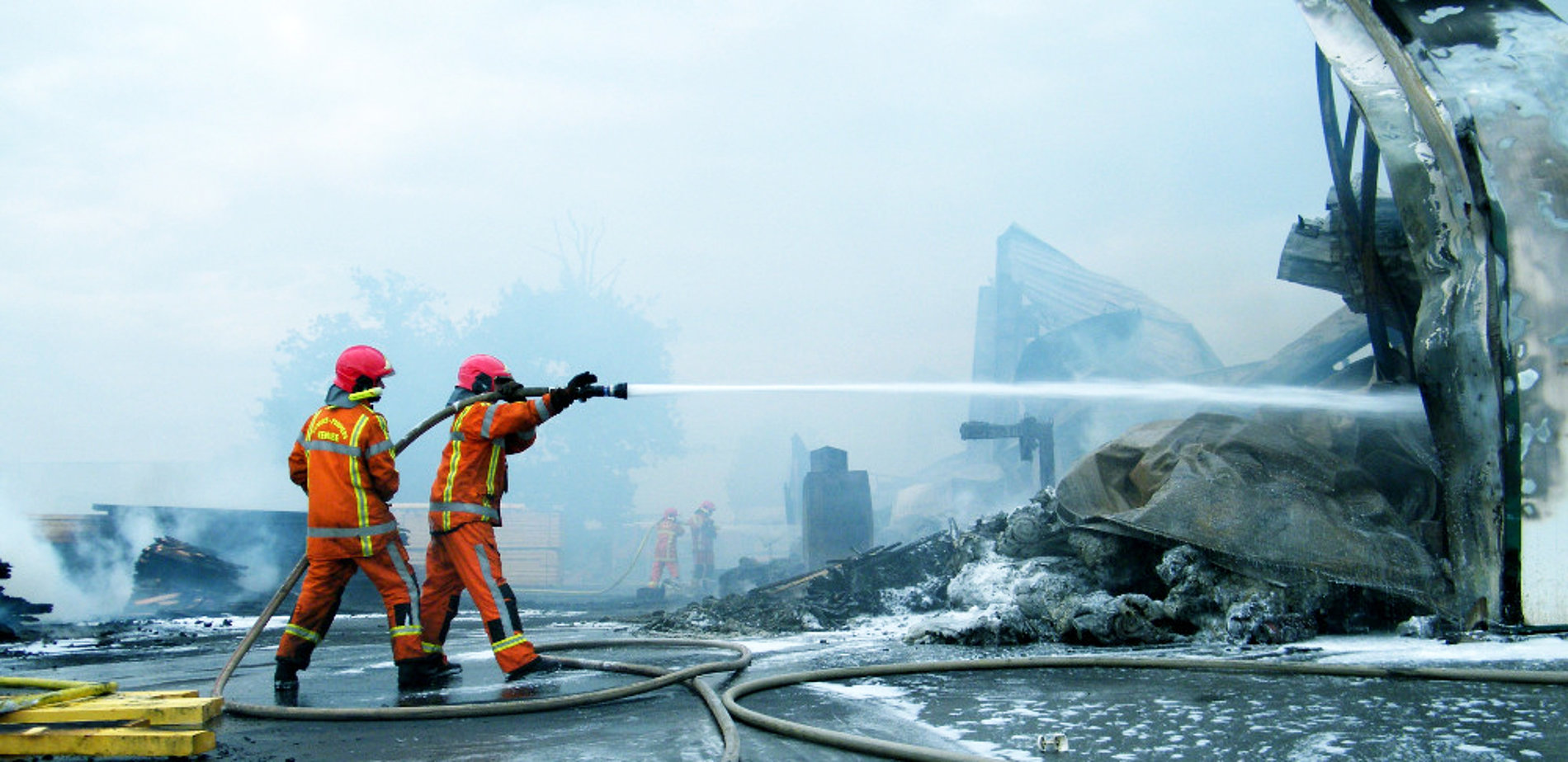 Photographie montrant 2 pompiers en intervention.