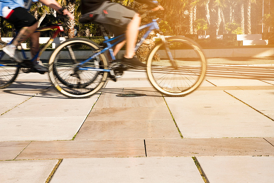 un homme qui fait du vélo sur un trottoir.